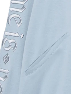 Błękitna bluza z kapturem i naszywkami